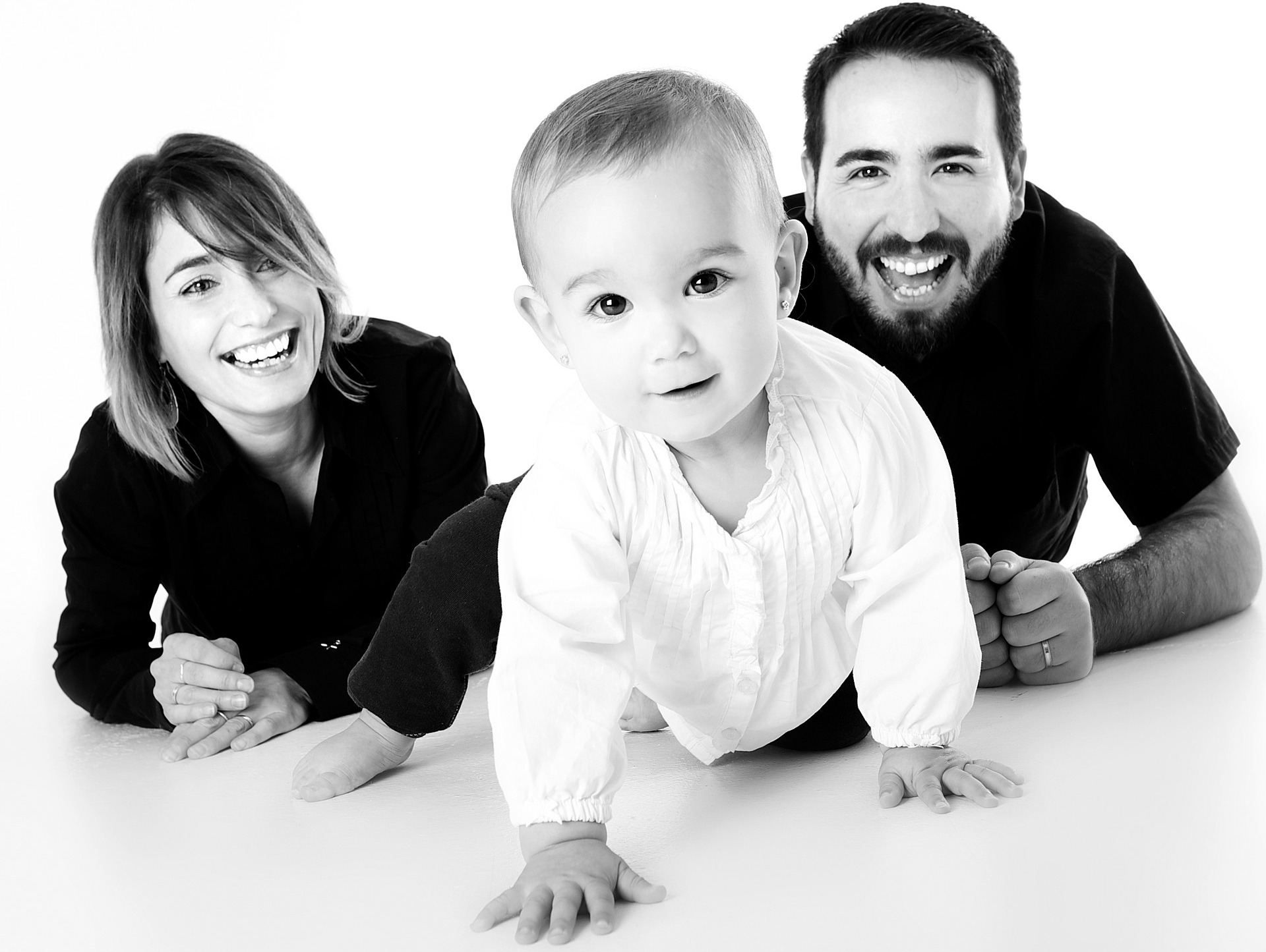 Un bébé rampe et ses parents l'encouragent