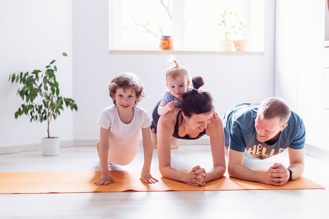 une famille fait du yoga dans son salon