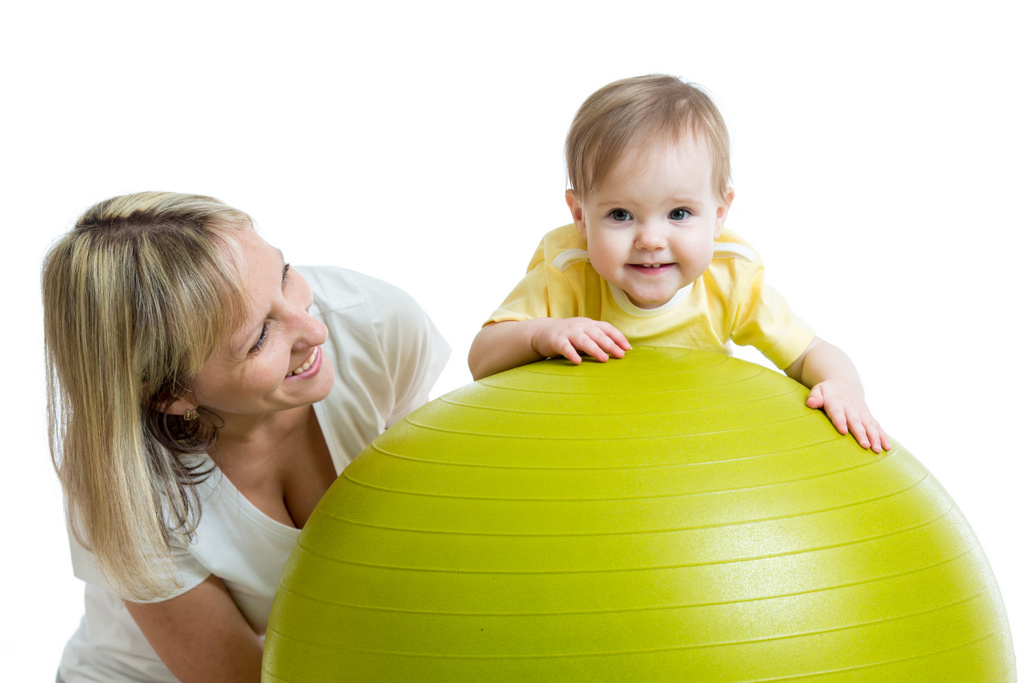Une maman joue avec son petit garçon sur un ballon