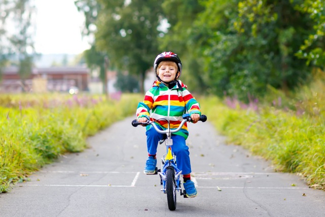 Un petit garçon fait du vélo sans roulettes